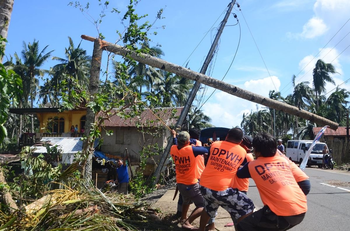 Workers pull a fallen electric pylon damaged at the height of Typhoon Phanfone in Salcedo town in Eastern Samar province on 26 December 2019. Photo: AFP
