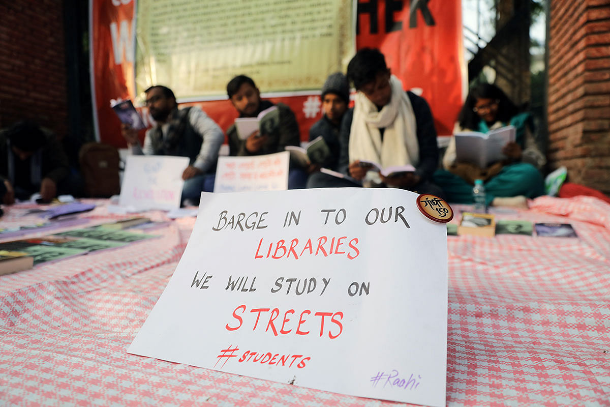 Students read books at a makeshift library on a street during a protest against a new citizenship law, outside the Jamia Millia Islamia university in New Delhi, India, on 26 December 2019. Photo: Reuters