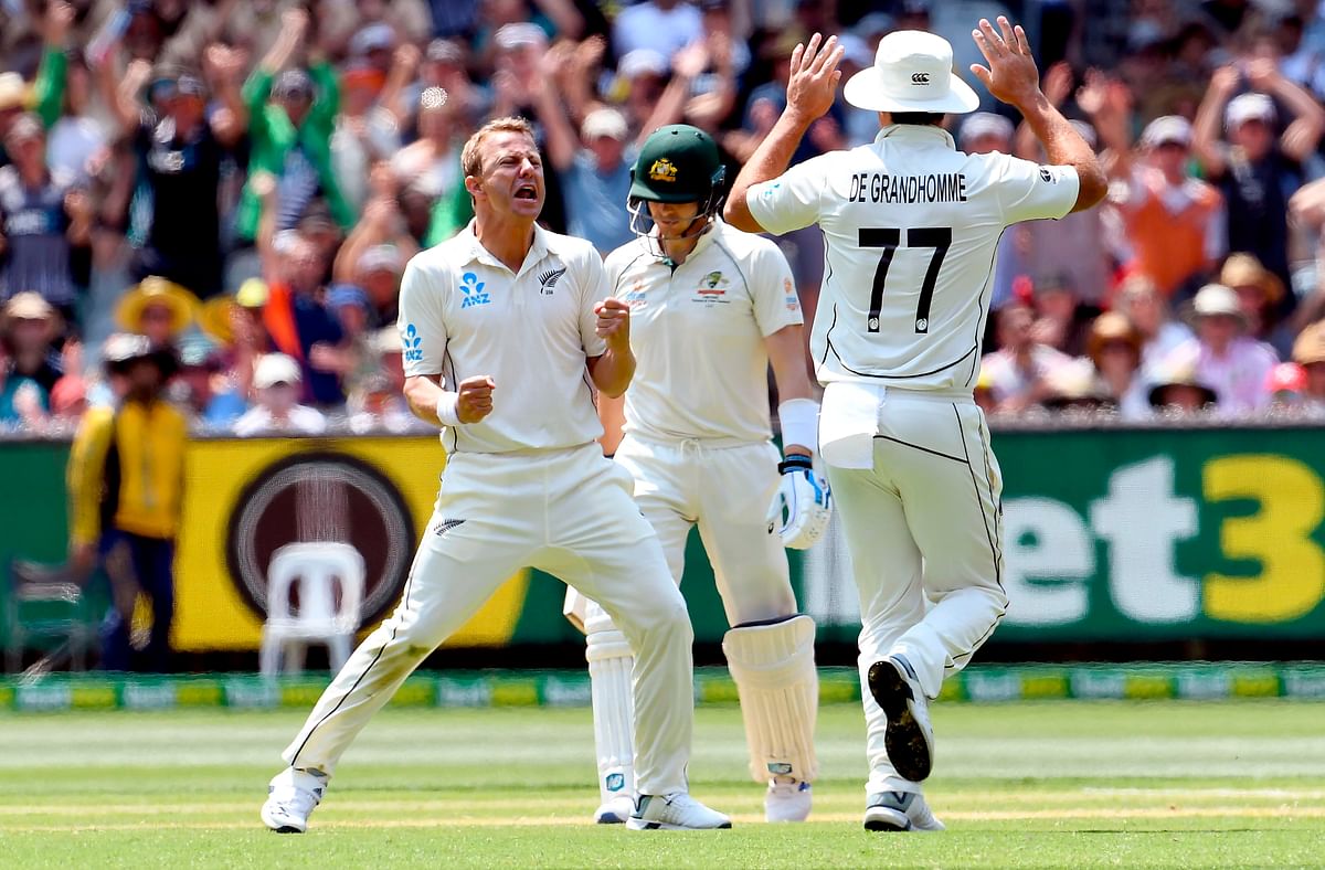 New Zealand bowler Neil Wagner (L) celebrates with teammate Colin de Grandhomme (R) after dismissing Australian batsman Steve Smith (C) on the second day of the second cricket Test match at the MCG in Melbourne on 27 December 2019. Photo: AFP