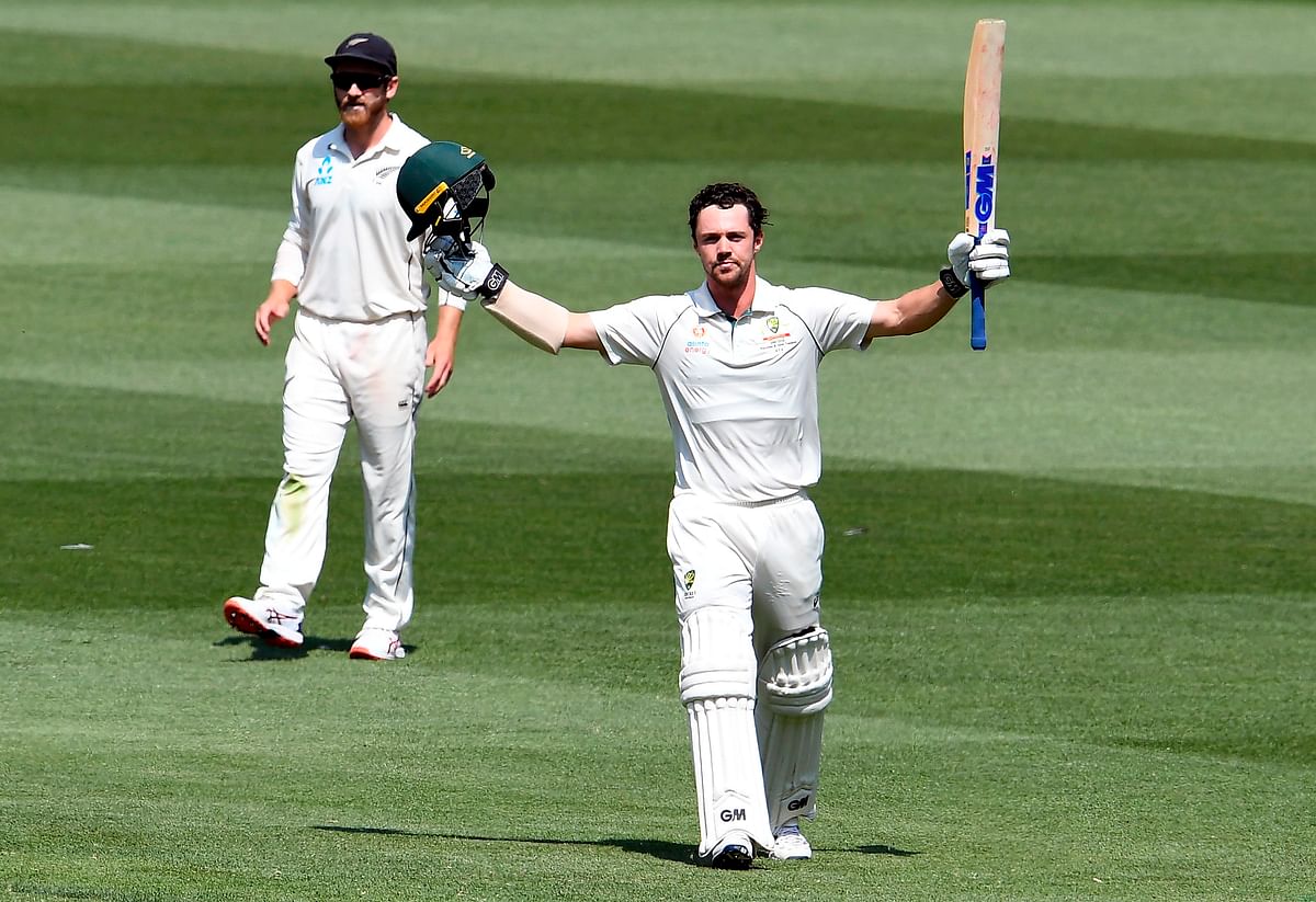 Australian batsman Travis Head celebrates scoring his century as New Zealand captain Kane Williamson (L) looks on during the second day of the second cricket Test match at the MCG in Melbourne on 27 December 2019. Photo: AFP