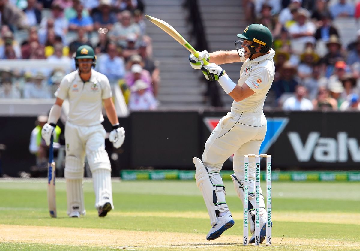 Australian batsman Tim Paine (R) pulls a ball away from the New Zealand bowling as teammate Travis Head (R) looks on during the second day of the second cricket Test match at the MCG in Melbourne on 27 December 2019. Photo: AFP