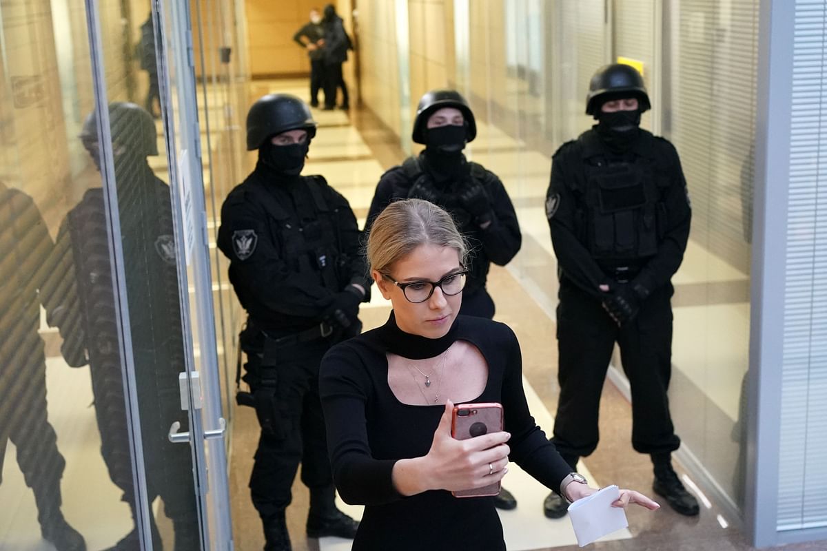Opposition politician Lyubov Sobol uses her smartphone while standing in front of law enforcement agents in a hallway of a business centre, which houses the office of opposition leader Alexei Navalny`s Anti-Corruption Foundation (FBK), in Moscow on 26 December 2019. Photo: AFP