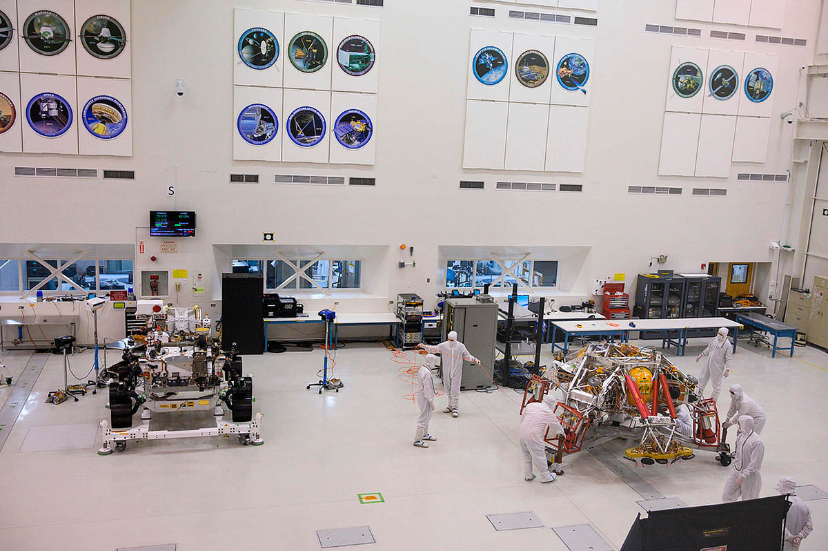 NASA engineers and technicians move the Mars 2020 spacecraft descent stage (R) closer to the Mars 2020 Rover (L), on 27 December 2019 during a media tour of the spacecraft assembly area clean room at NASA`s Jet Propulsion Laboratory in Pasadena, California. Photo: AFP