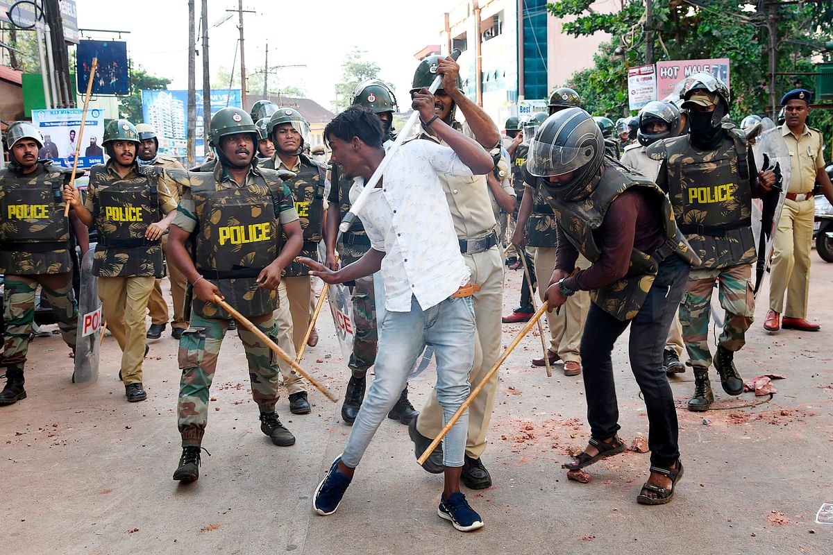 In this file picture taken on 19 December 2019, policemen with sticks locally known as `lathi` beat a protester during a demonstration against India`s new citizenship law in Mangalore. Photo: AFP