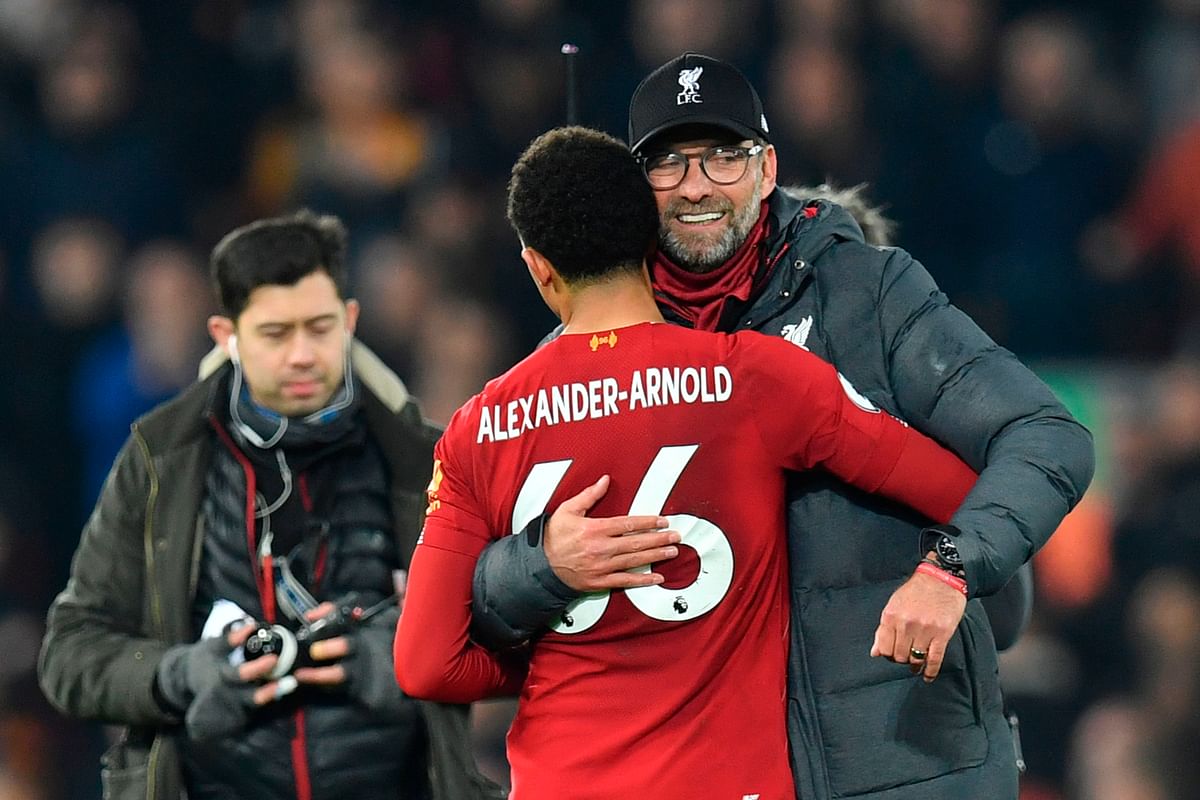 Liverpool`s German manager Jurgen Klopp (R) embraces Liverpool`s English defender Trent Alexander-Arnold (L) at the end of the English Premier League football match between Liverpool and Wolverhampton Wanderers at Anfield in Liverpool, north west England, on 29 December, 2019. Photo: AFP