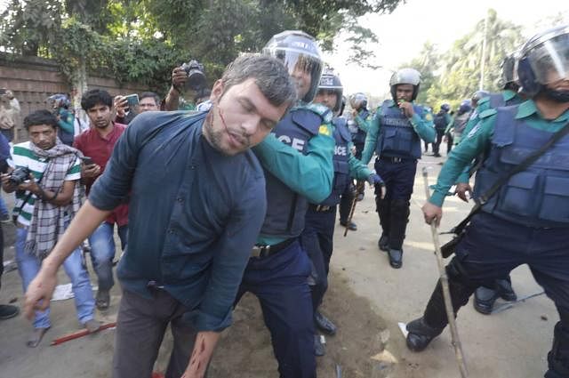 A protester is caught by the police. Photo: Shuvra Kanti Das