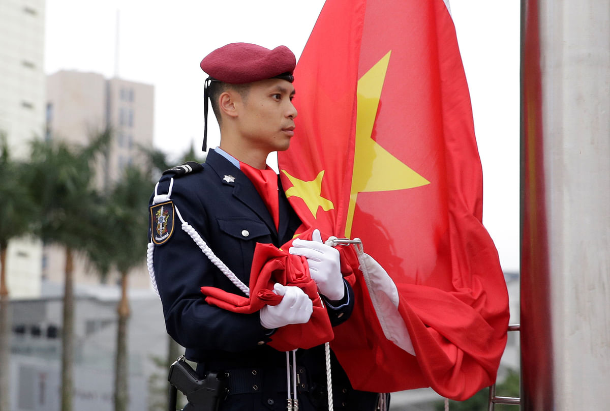 A policeman holds a Chinese national flag during a flag-raising ceremony at the Golden Lotus Square in Macau, China on 19 December, on the eve of the 20th anniversary of the former Portuguese colony`s return to China. Photo: Reuters
