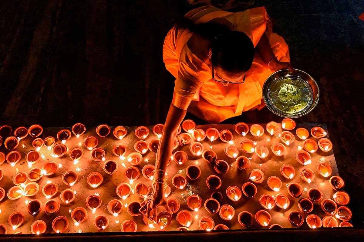 A Hindu devotee lights an oil lamp at a Hindu temple in Colombo on 1 January 2020. Photo: AFP