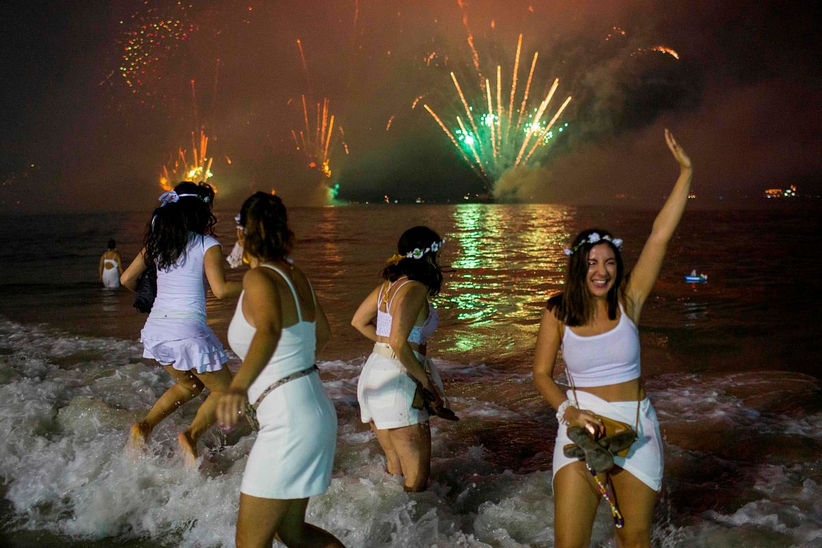A group of women lap waves as a brazilian tradition as they watch the traditional New Year`s fireworks at Copacabana Beach in Rio de Janeiro, Brazil, on 31 December 2019. Photo: AFP
