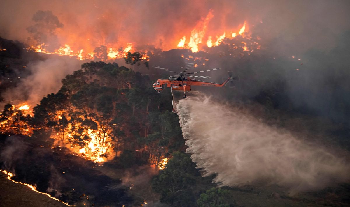 A handout photo taken and received on 31 December 2019 from the State Government of Victoria shows a helicopter fighting a bushfire near Bairnsdale in Victoria`s East Gippsland region. Photo: AFP