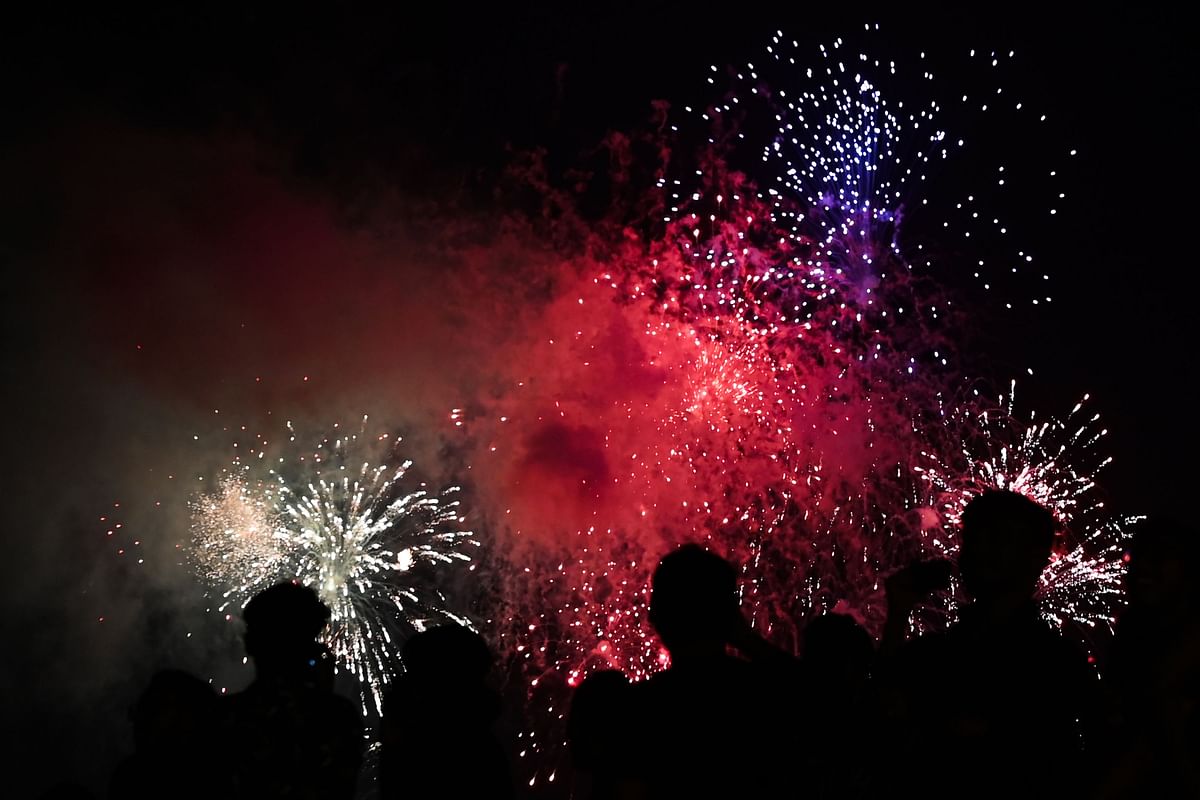 People watch fireworks erupting in the sky of Colombo during New Year`s celebrations on 1 January 2020. Photo: AFP