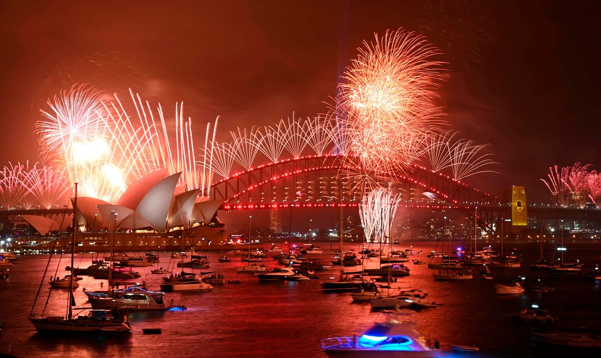New Year`s Eve fireworks erupt over Sydney`s iconic Harbour Bridge and Opera House (L) during the fireworks show on 1 January 2020. Photo: AFP
