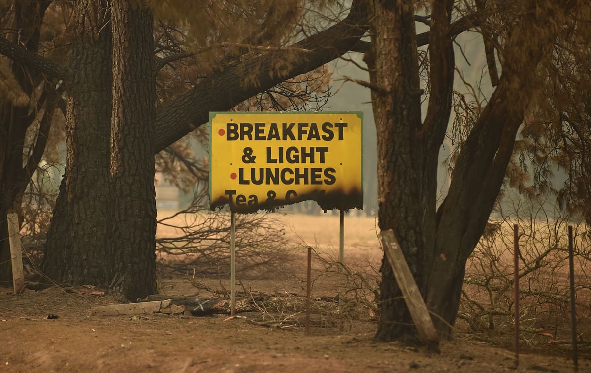 A sign is seen half burnt after bushfires ravaged the town of Bilpin, 70km west of Sydney on 29 December 2019. Photo: AFP