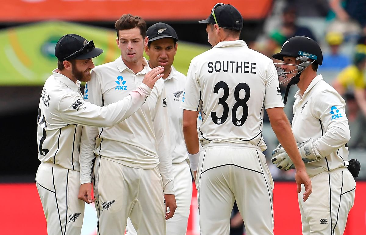 New Zealand bowler Mitchell Santner (2nd L) is congratulated by teammate Kane Williamson (L) after dismissing Australia`s Joe Burns on the third day of the second cricket Test match at the MCG in Melbourne on 28 December 2019. Photo: AFP