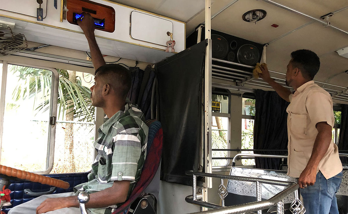 A man (R) cleans the speakers of a bus in Biyagama on 2 January 2020. Sri Lanka`s government on January 2 gave bus operators two weeks to turn down the notoriously loud music in their vehicles following complaints from passengers. Photo: AFP