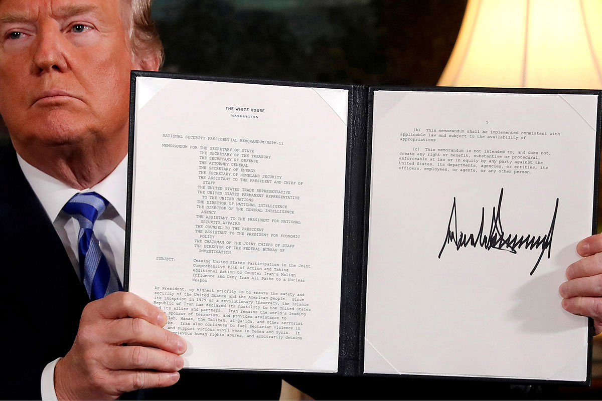 US president Donald Trump holds up a proclamation declaring his intention to withdraw from the JCPOA Iran nuclear agreement after signing it in the Diplomatic Room at the White House in Washington, US on 8 May 2018. Reuters File Photo