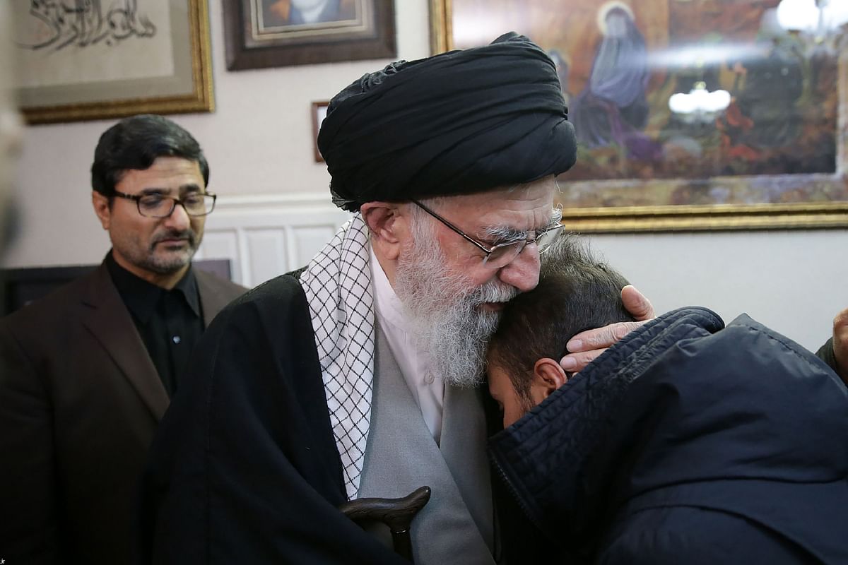 A handout picture provided by the office of Iran`s supreme leader Ayatollah Ali Khamenei on 3 January 2020, shows him (C) embracing a relative of killed Iranian Revolutionary Guards commander Qasem Soleimani, in the capital Tehran. Photo: AFP