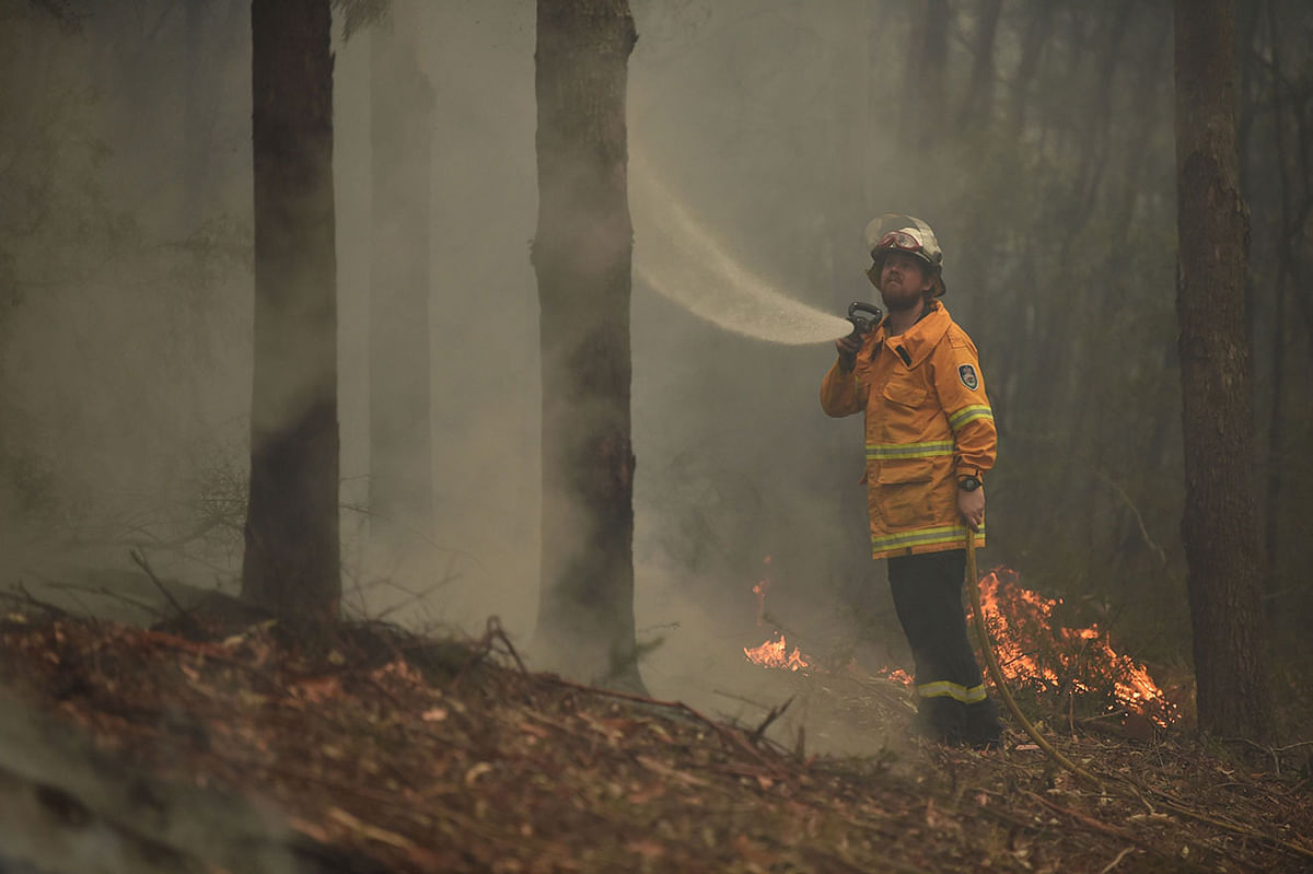 A firefighter tackles a bushfire south of Nowra on 5 January, 2020. Photo: AFP