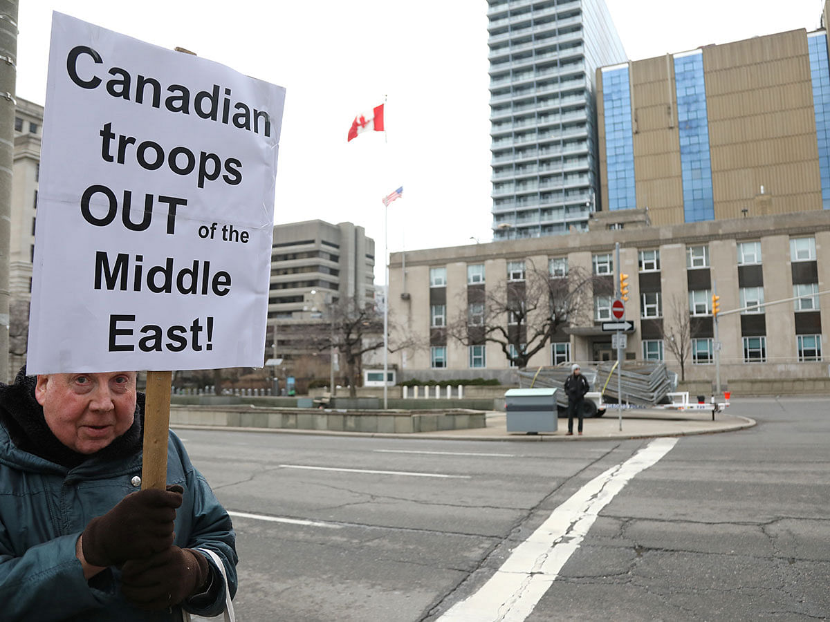 A demonstrator holds a sign calling for Canada to withdraw its troops from the Middle East, during a protest against war amid increased tensions between the United States and Iran, outside the United States consulate in Toronto, Ontario, Canada on 4 January 2020. Photo: Reuters
