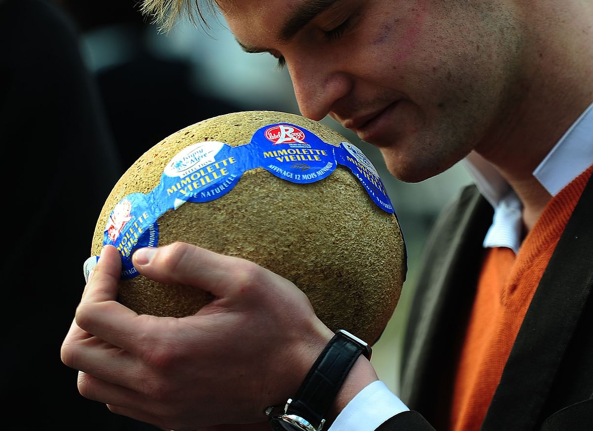 In this file photo taken on 13 April, 2013, importers and supporters offerssamples of French cheese Mimolette to pedestrians during an event to support the import in the US of the 17th century-old cheese, after the US Food and Drug Administration (FDA) blocked the cheese to enter the territory in New York. Photo: AFP