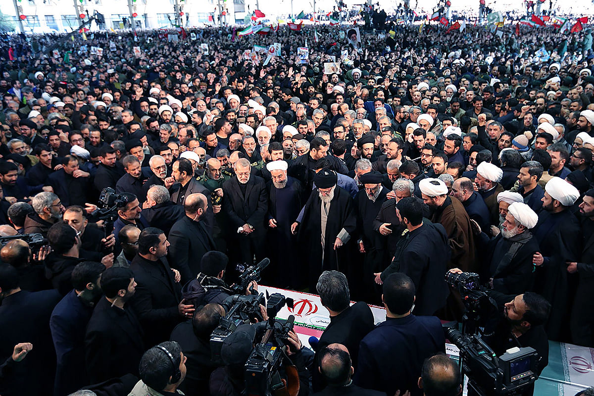A handout picture provided by the Iranian Presidency website shows Iran`s supreme leader Ayatollah Ali Khamenei (C) and president Hassan Rouhani standing next to him and other officials paying their respect to the slain Iranian military commander Qasem Soleimani and Iraqi paramilitary chief Abu Mahdi al-Muhandis at Tehran University in the Iranian capital on 6 January, 2020. Photo: AFP