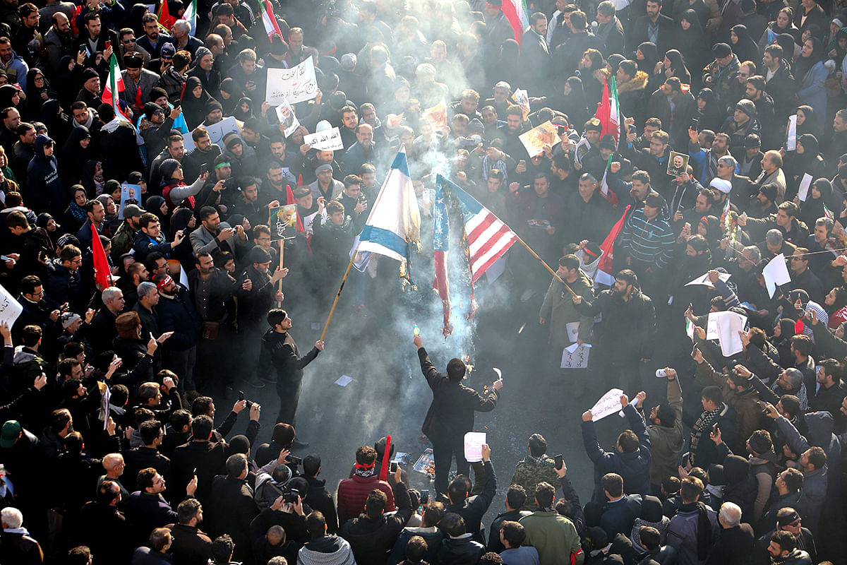 Iranians set a US and an Israeli flag on fire during a funeral procession organised to mourn the slain military commander Qasem Soleimani, Iraqi paramilitary chief Abu Mahdi al-Muhandis and other victims of a US attack in the capital Tehran on 6 January, 2020. Photo: AFP