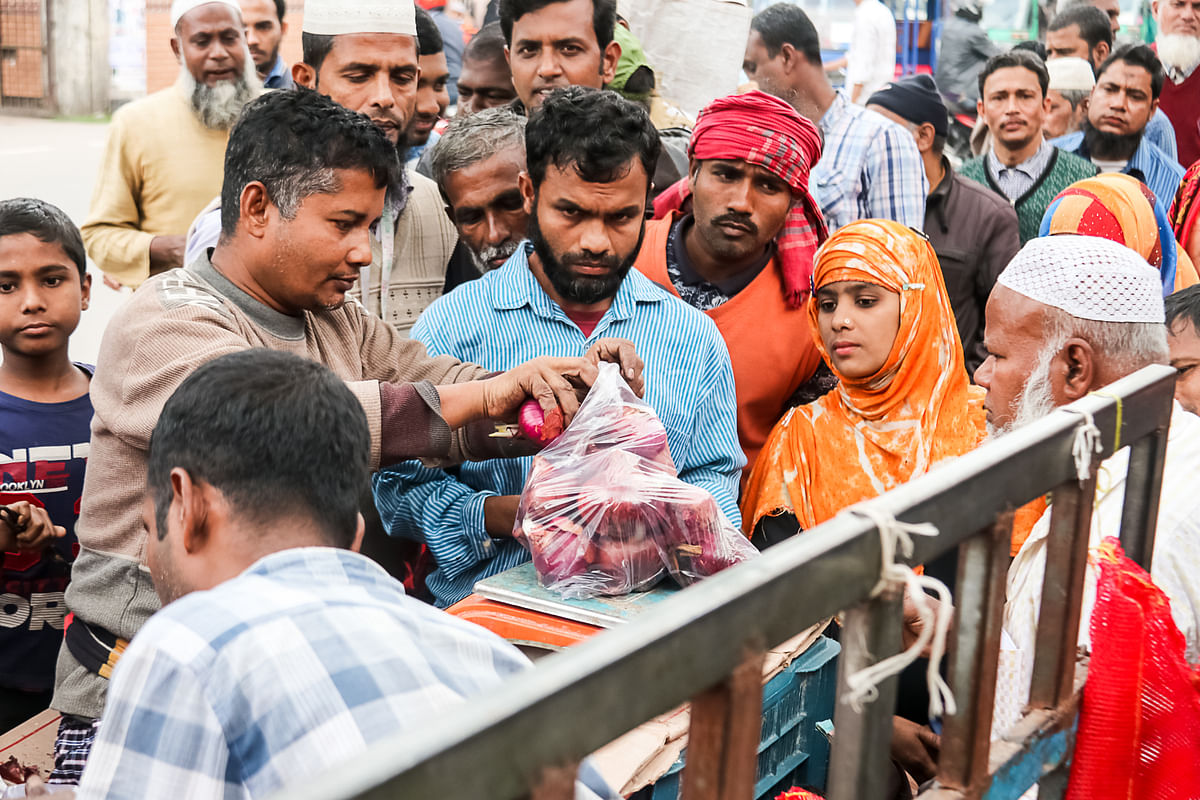 People wait in a queue to buy subsidised onions of Trading Corporation of Bangladesh (TCB), a wing of the commerce ministry, amid shortage of the vegetable in front of the city corporation office in Barishal on 5 January 2019. Photo: Saiyan