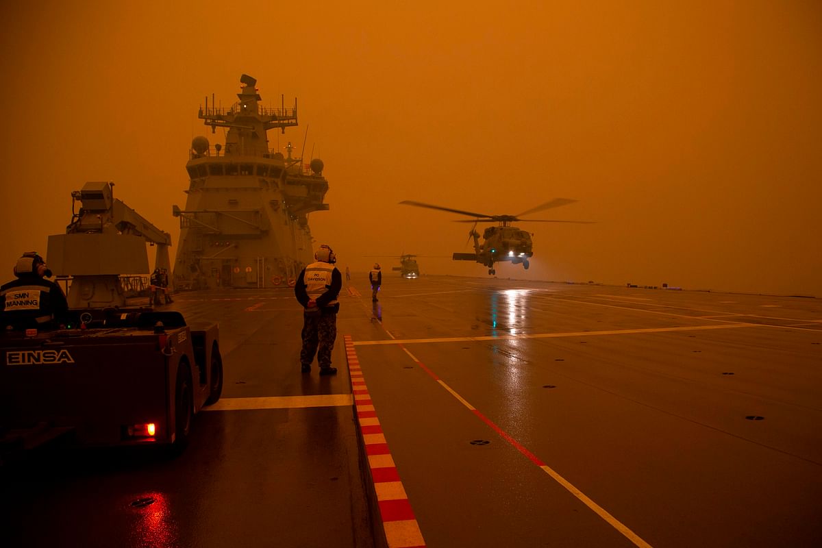 This handout photo taken on 5 January and received on January 6 from the Australian Department of Defence shows Royal Australian Navy MH-60R Seahawk `Romeo` helicopters departing HMAS Adelaide (L01) as part of bushfire relief operations. Photo: AFP