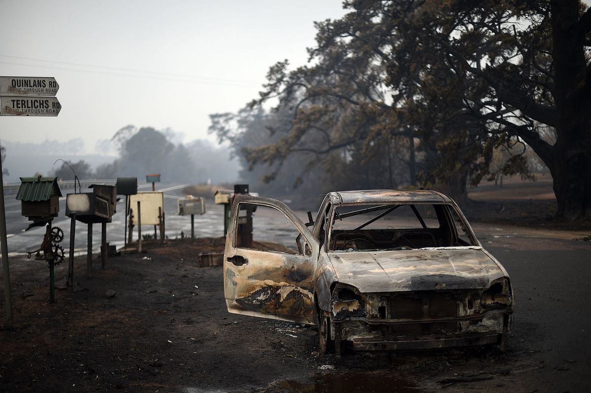 A burnt vehicle is seen on Quinlans street after an overnight bushfire in Quaama in Australia`s New South Wales state on 6 January. Photo: AFP