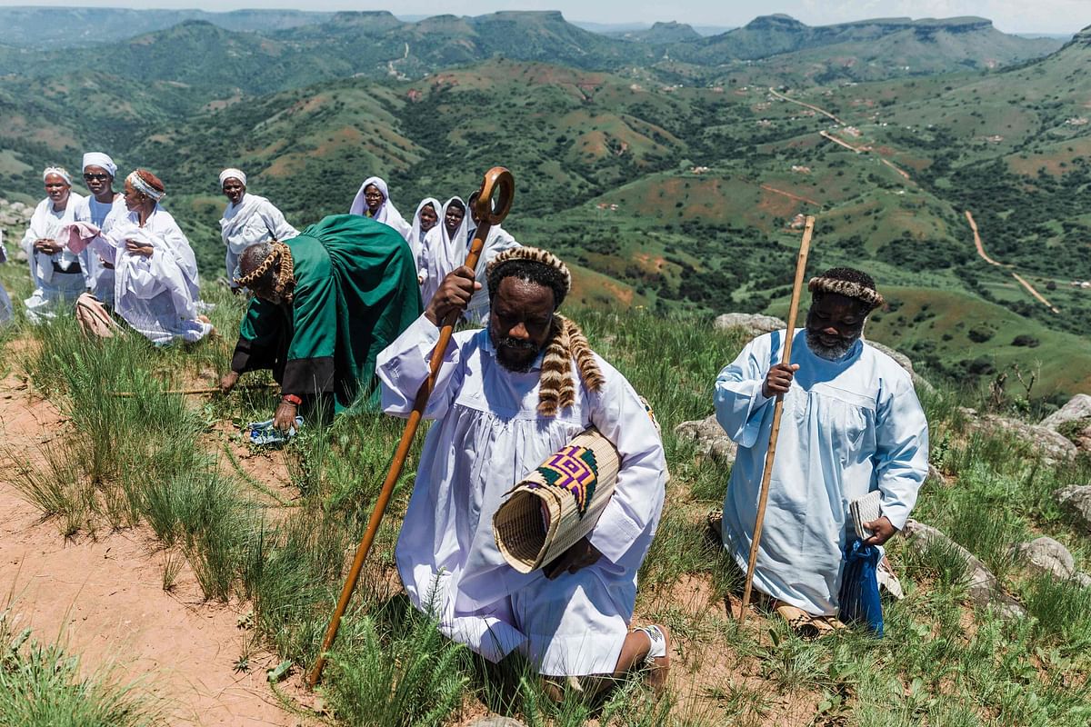 Worshippers of the Nazareth Baptist Church of the Ekuphakameni group also known as the Shembe Church dressed in traditional attire kneel down to pray at the Nhlangakazi Holy Mountain in Ndwedwe 85 kilometres north of Durban on 4 January 2020. This AFP photo has been used symbolically.