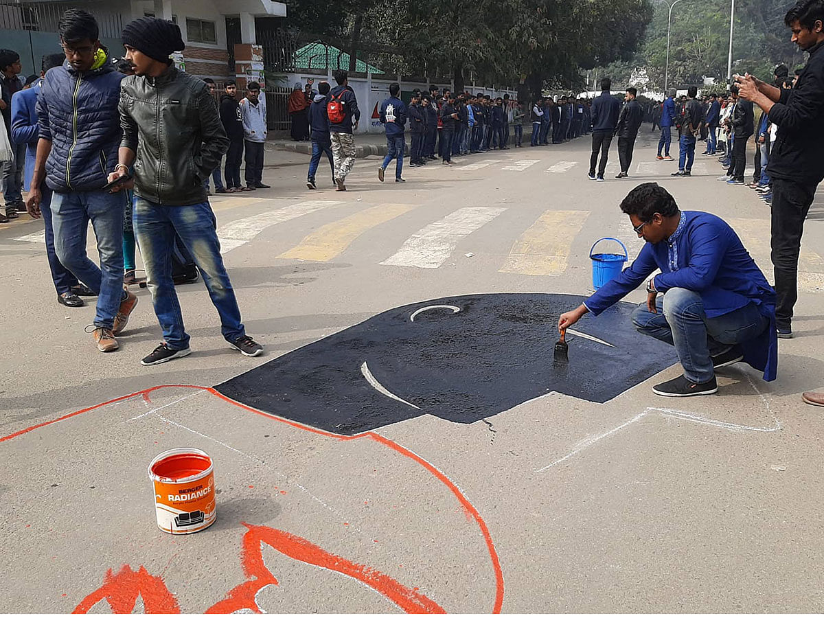 Students of the fine arts faculty, Dhaka University, on 7 January 2019, paint on the road in front of the university’s Ruqayyah Hall protesting against the rape of a DU student in the capital. Photo: Sajid Hossain