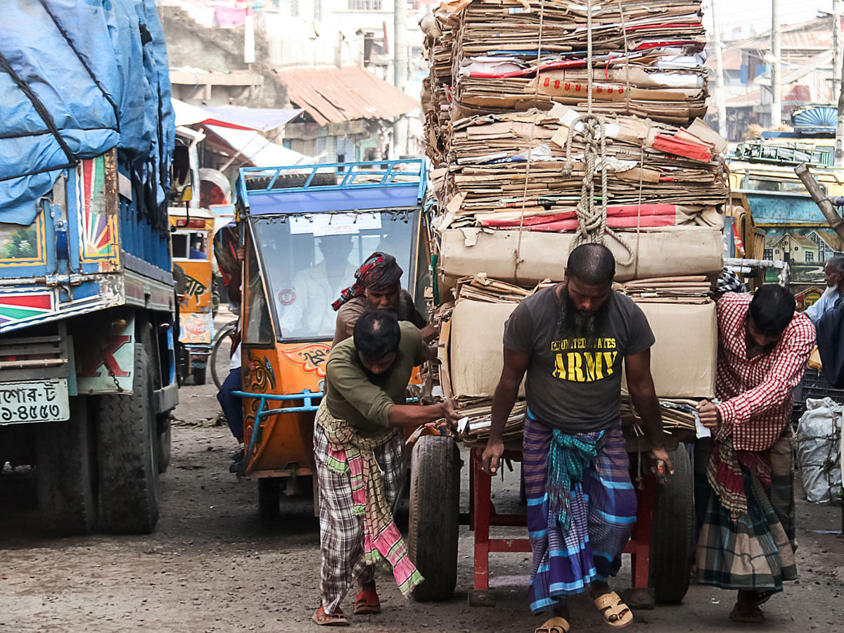 Workers push an overloaded cart towards a bridge at Port Road, Barishal on 7 January 2019. Photo: Saiyan