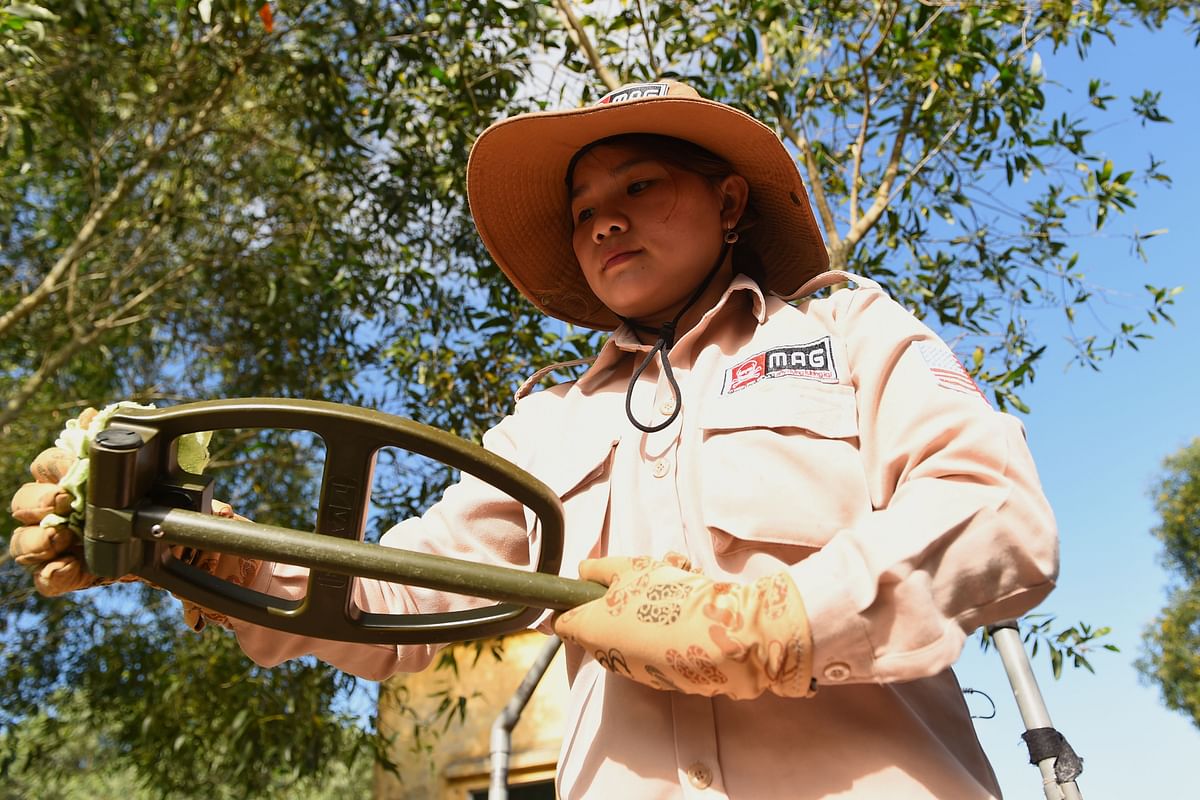 This picture taken on 6 January 2020 shows a member of an all-female demining team cleaning a detector used to find unexploded ordnance at a landmine site in the Trieu Phong district in Quang Tri province. Photo: AFP