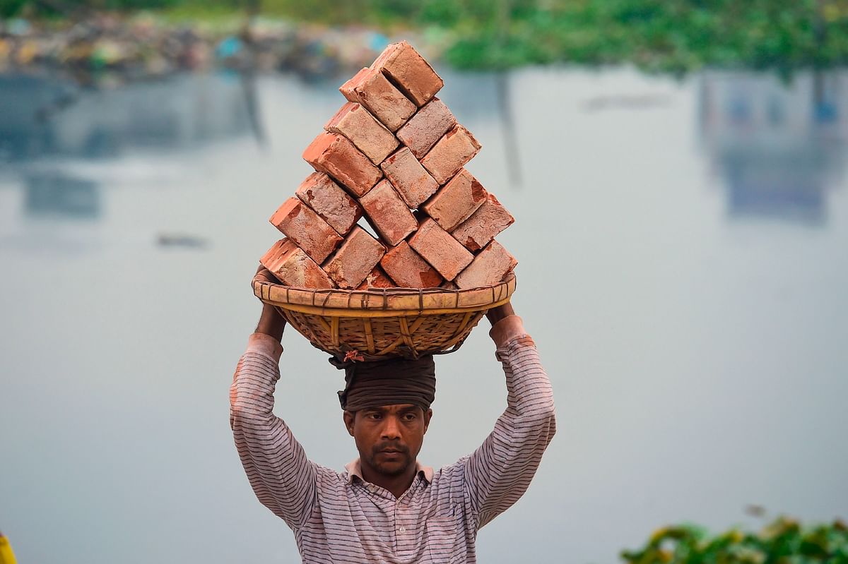A labourer unloads bricks from a boat on the outskirts of Dhaka 9 on January 2020. Photo: AFP