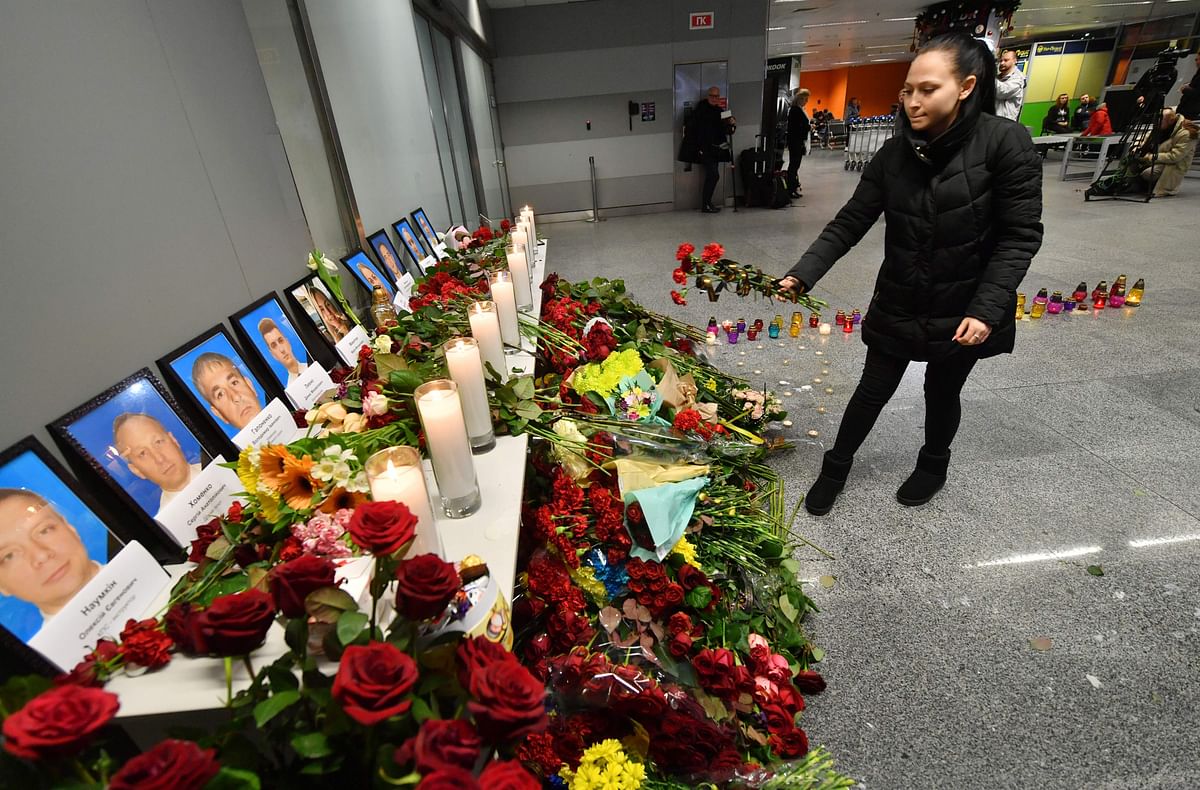 A woman places flowers at a memorial for the victims of the Ukraine International Airlines Boeing 737-800 crash in the Iranian capital Tehran, at the Boryspil airport outside Kiev on 8 January. Photo: AFP