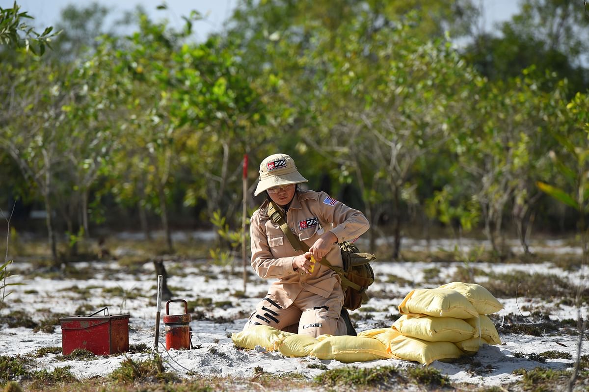 This picture taken on 6 January 2020 shows a member of an all-female demining team preparing to detonate unexploded ordnance at a landmine site in the Trieu Phong district in Quang Tri province. Photo: AFP