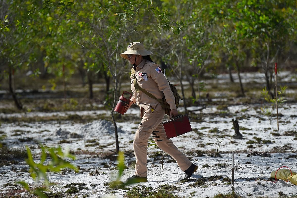 This picture taken on 6 January 2020 shows a member of an all-female demining team walking with equipment to help clear unexploded ordnance at a landmine site in the Trieu Phong district in Quang Tri province. Photo: AFP