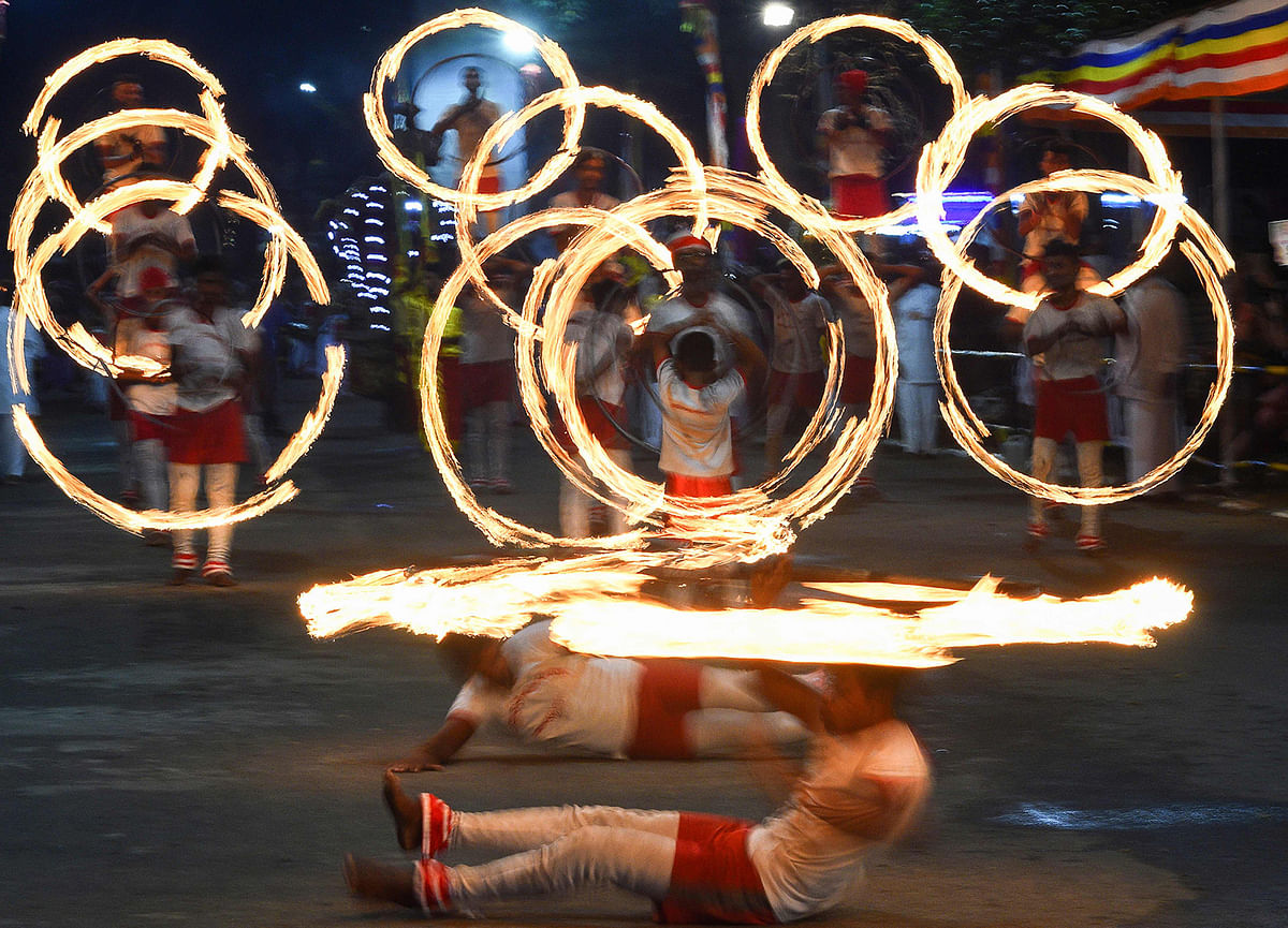 In this photograph taken on 9 January 2020, fire dancers perform in a parade at the annual Perahera festival at the historic Kelaniya Buddhist temple in Kelaniya. Photo: AFP