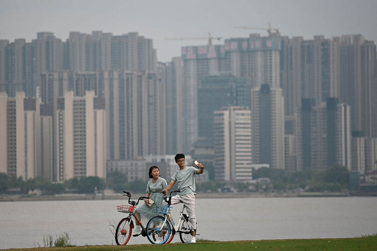 This picture taken on 6 September 2019 shows a man taking a selfie with a woman along the banks of the Yangtze River in Nanjing in China`s Jiangsu province. Photo: AFP