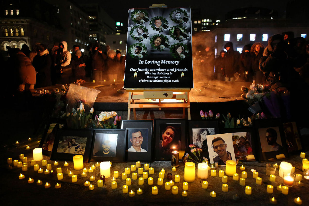 An altar with photographs of the victims who were killed in a plane crash in Iran is seen as people gather around to held a vigil in their memories on 9 January in Ottawa, Canada. Photo: AFP