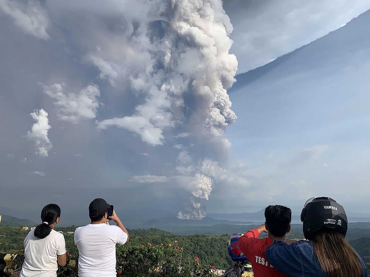 People take photos of a phreatic explosion from the Taal volcano as seen from the town of Tagaytay in Cavite province, southwest of Manila, on 12 January, 2020. Photo: AFP