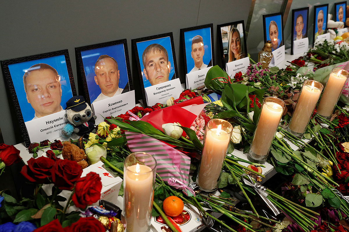Flowers and candles are placed in front of the portraits of the flight crew members of the Ukraine International Airlines Boeing 737-800 plane that crashed in Iran, at a memorial at the Boryspil International airport outside Kiev, Ukraine on 11 January. Photo: Reuters