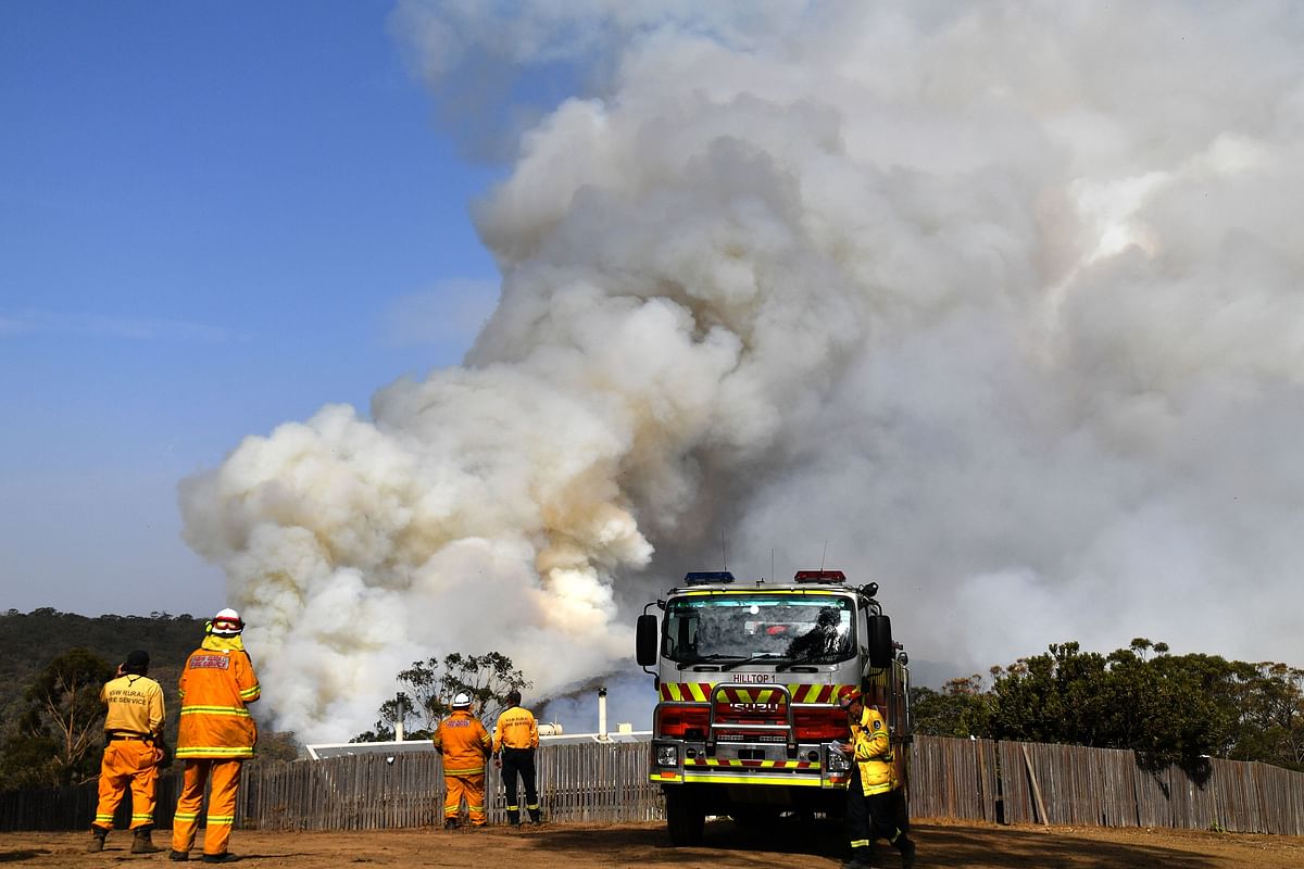 Firefighters work as smoke rises from a bushfire in Penrose, in Australia`s New South Wales state on 10 January 2020. Photo: AFP