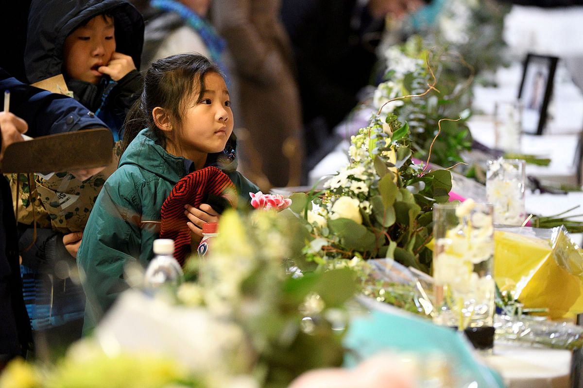 Flowers and photos of the victims set up at a memorial service at the University of Alberta for the victims of a Ukrainian passenger plane that crashed in Iran, in Edmonton, Alberta, Canada 12 January, 2020. Photo: Reuters