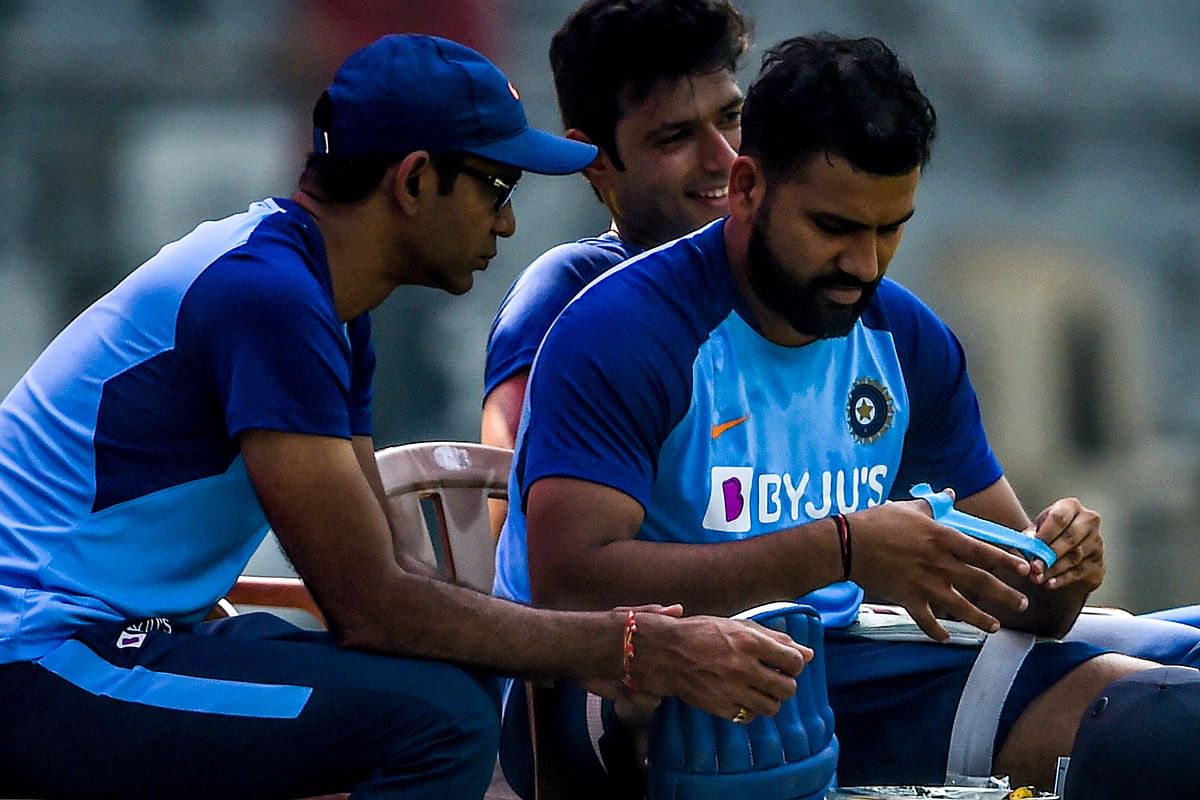 India`s team physiotherapist Nitin Patel (L) looks on as Rohit Sharma (R) takes a bandage off his thumb following an injury during a training session ahead of the upcoming cricket three-match one day international (ODI) series against Australia, at Wankhede Stadium in Mumbai on 12 January, 2020. Photo: AFP