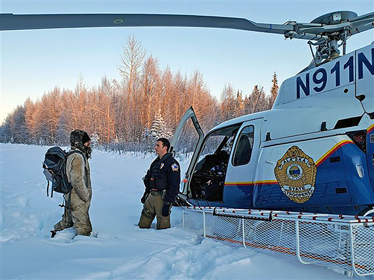 This Alaska State Trooper handout photo obtained 12 January, 2020, shows a member of the Alaska State Troopers speaking with Tyson Steele, 30(L), who was rescued on 9 January, 2020 having survived more than 20 days in subzero temperatures after his cabin in a remote area of the Susitna Valley burned down. Photo: AFP