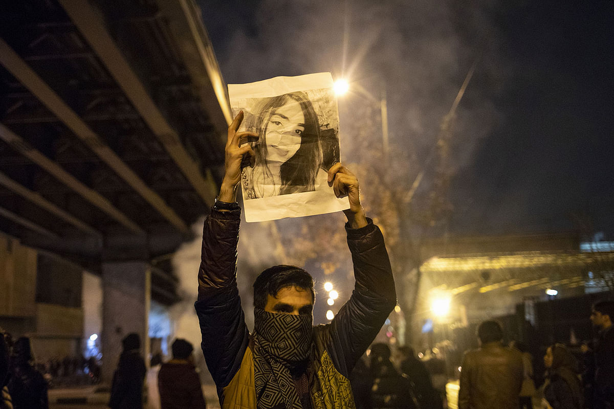 An Iranian man holds a picture of a victim of the Ukrainian Boeing 737-800 plane crash during a demonstration in front of Tehran`s Amir Kabir University on 11 January, 2020. Photo: AFP