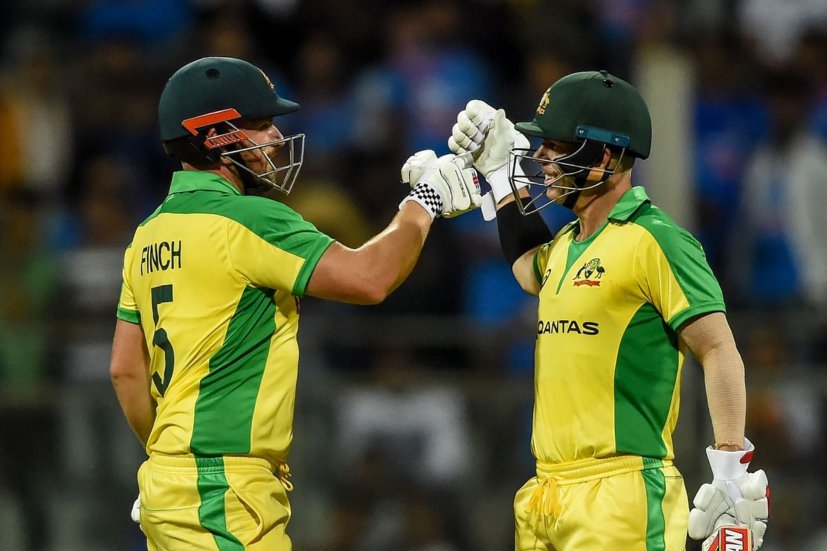 Australia`s Aaron Finch (L) and teammate David Warner (R) celebrate after each scored a century (100 runs) during the first one day international (ODI) cricket match of a three-match series between India and Australia at the Wankhede Stadium in Mumbai on January 14, 2020. AFP