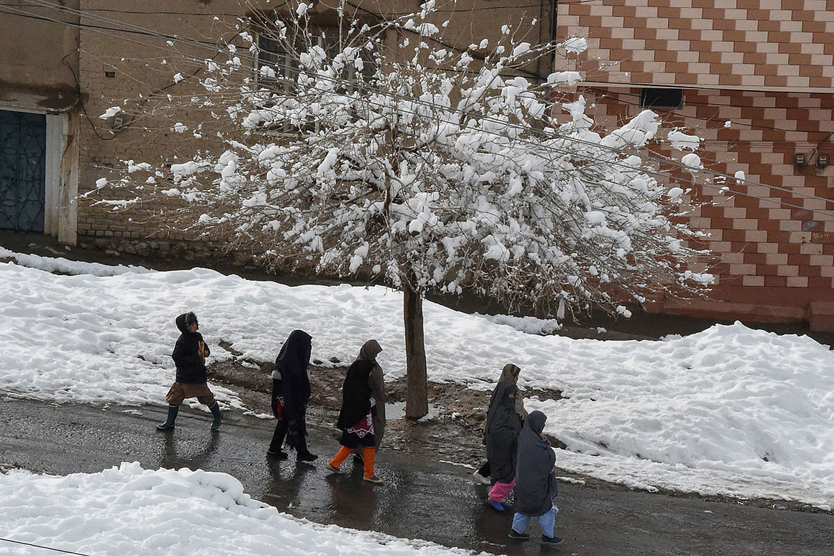 People walk on a street after heavy snowfall in Quetta on 13 January, 2020. Photo: AFP