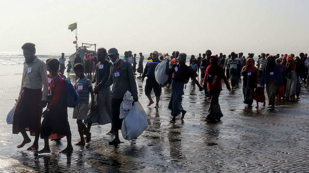 Rohingya people who were arrested at sea in December walk on a beach after being transported by Myanmar authorities to Thalchaung near Sittwe in Rakhine state on 13 January, 2020. Photo: AFP